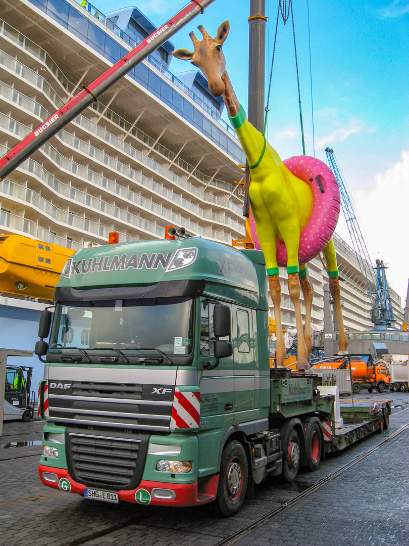 Spezialtransport einer 9 Meter hohen Giraffen Kunstskulptur fuer das Kreuzfahrtschiff Anthem of the Seas der Reederei Royal Carribbean. Die handgefertigte Giraffe Gigi wurde vom franzoesischen Künstler Jean-Francois Fourtou gefertigt. Der Transport erfolgt mit einem teleskopierbaren 2-Achs-Tiefbett und Kesselbrückentransporter.